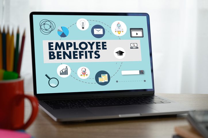 Laptop screen showing the text "EMPLOYEE BENEFITS" with various icons around it.