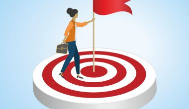 Business professional standing on a red-and-white target holding a flag, symbolizing achieving leadership goals and success.