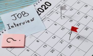 Professional workspace with notebooks, pens, and a calendar, symbolizing organized communication and the process of professionally rescheduling a job interview.