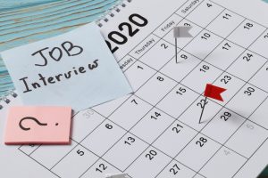Professional workspace with notebooks, pens, and a calendar, symbolizing organized communication and the process of professionally rescheduling a job interview.